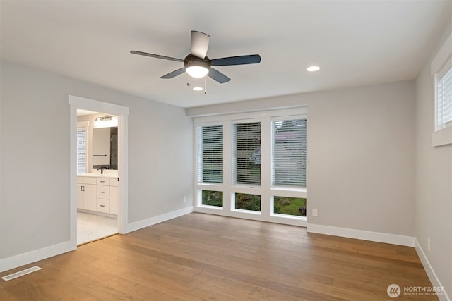 interior space featuring light wood-style flooring, baseboards, and ceiling fan