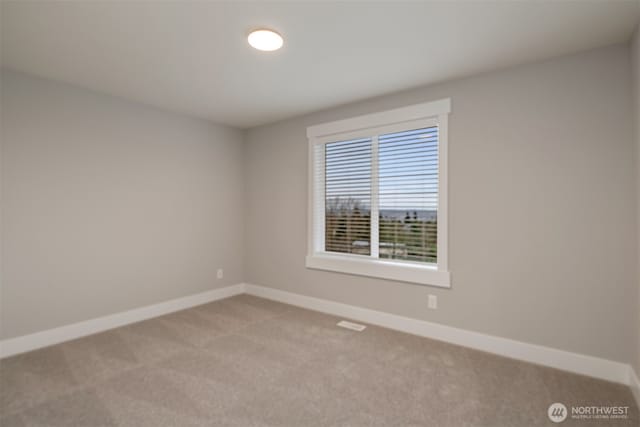 unfurnished room with visible vents, carpet, and baseboards