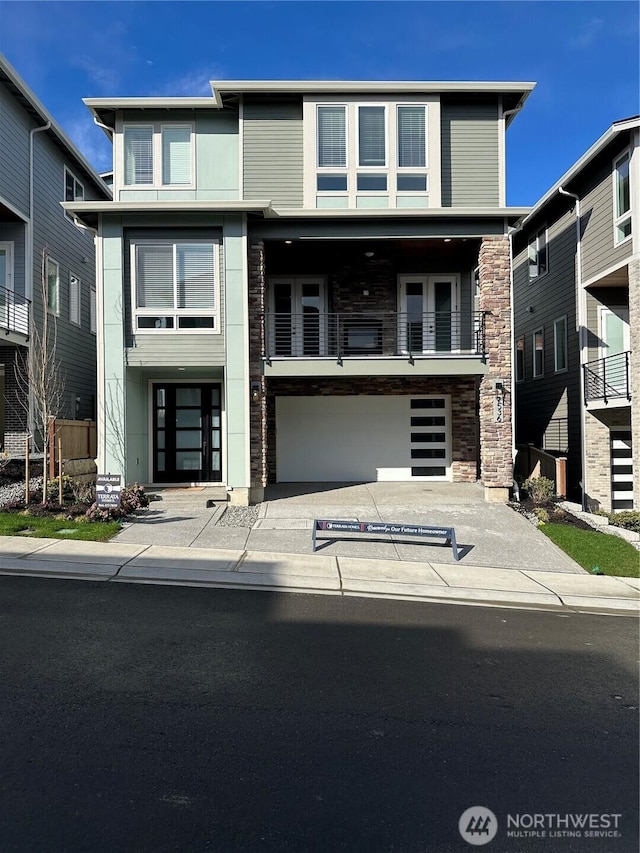 view of front of home with stone siding, concrete driveway, and a garage