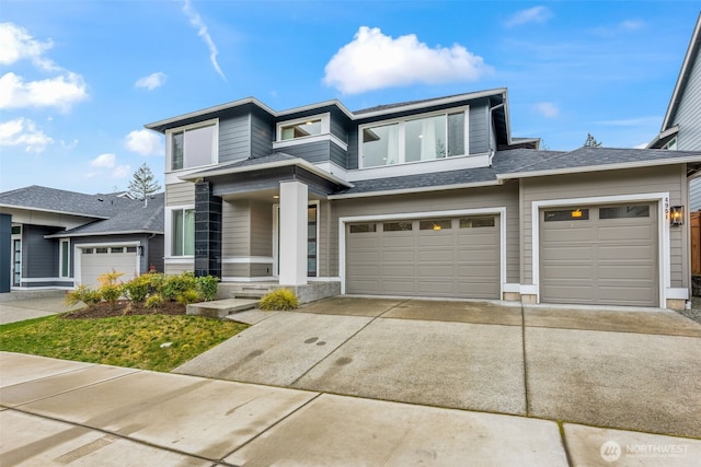 prairie-style home featuring concrete driveway, a garage, and a shingled roof