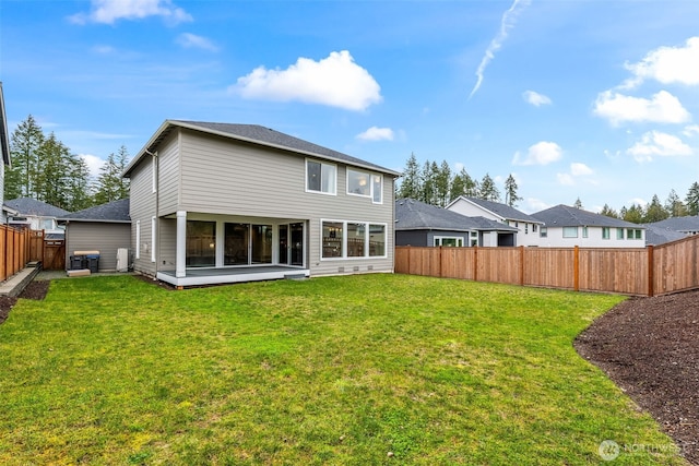 rear view of house featuring a lawn, central AC, and a fenced backyard