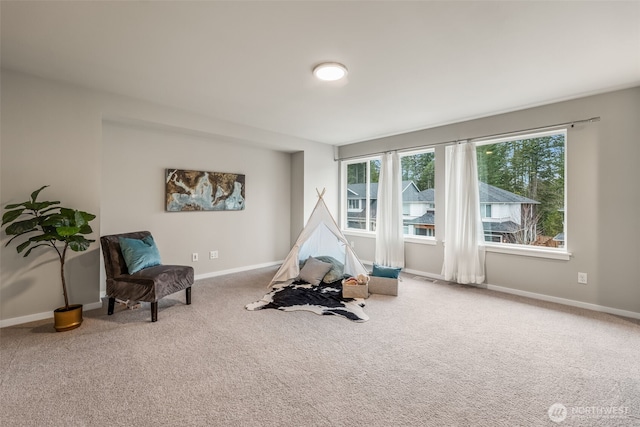 recreation room featuring baseboards and carpet