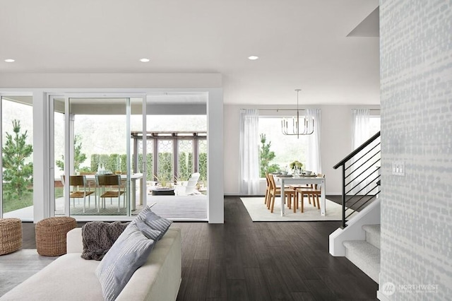 doorway to outside featuring a notable chandelier, stairway, wood finished floors, and recessed lighting