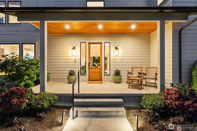 view of exterior entry with a porch and board and batten siding