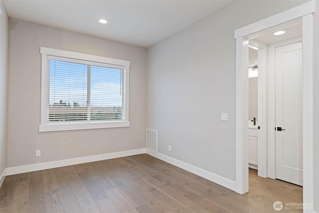 unfurnished room featuring visible vents, baseboards, wood finished floors, and recessed lighting