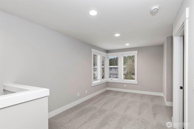 empty room featuring recessed lighting, light colored carpet, and baseboards