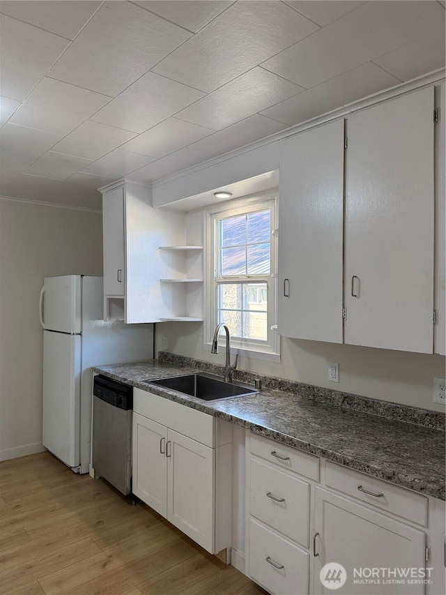 kitchen with light wood-style flooring, a sink, white cabinets, freestanding refrigerator, and dishwasher