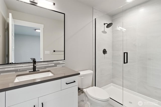 full bathroom with a stall shower, backsplash, toilet, and vanity