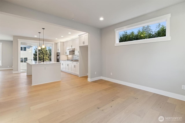 interior space featuring recessed lighting, a sink, light wood-style flooring, and baseboards