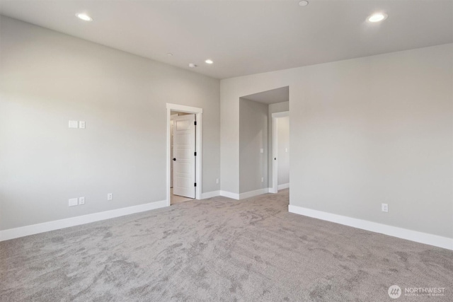 spare room with baseboards, light carpet, and recessed lighting