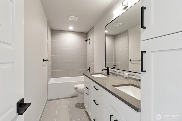 full bath featuring double vanity, visible vents, toilet, tile patterned floors, and a sink