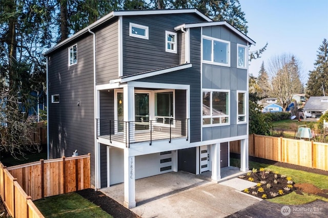 view of front facade featuring driveway, an attached garage, and fence