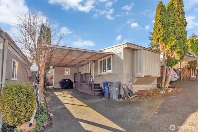 manufactured / mobile home featuring a carport and driveway