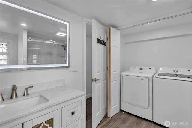 laundry room featuring dark wood-style floors, laundry area, washing machine and clothes dryer, and a sink