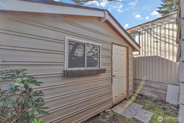 view of side of property with an outbuilding and fence