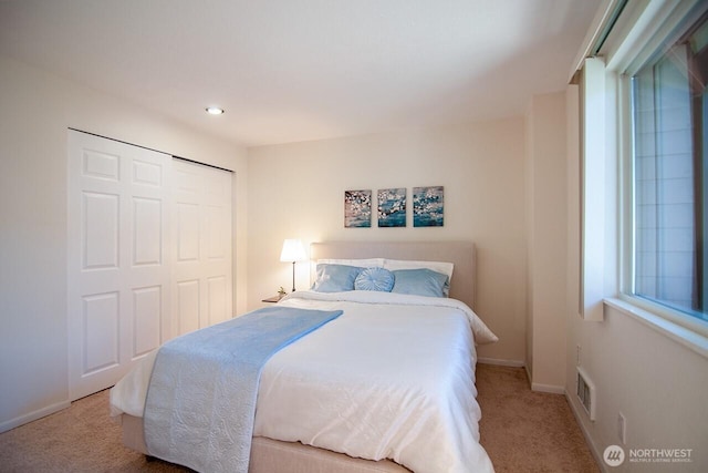 bedroom featuring baseboards, a closet, visible vents, and carpet flooring