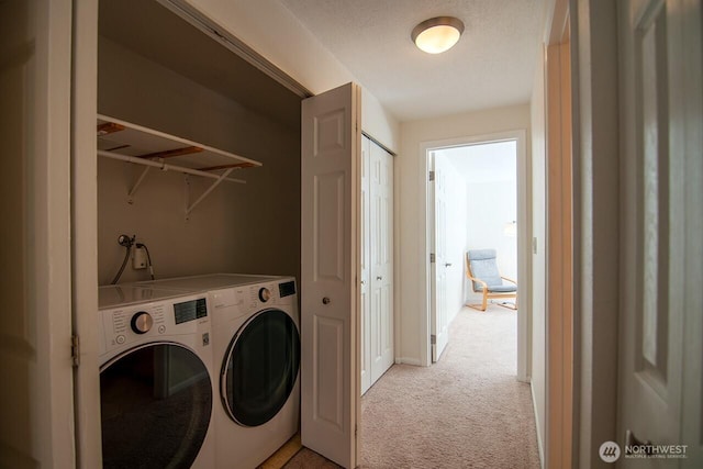 clothes washing area featuring light carpet, laundry area, and washer and dryer