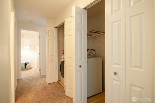 hall featuring light carpet and washer / dryer