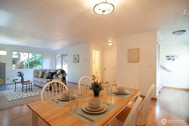 dining room featuring baseboards, ornamental molding, and wood finished floors