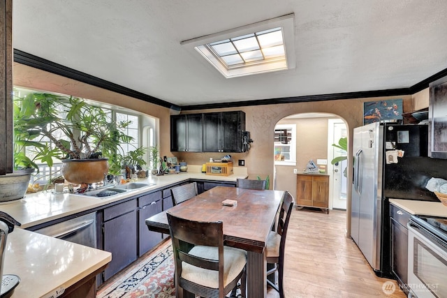 kitchen with arched walkways, crown molding, and light countertops