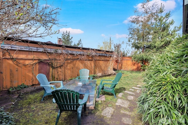 view of yard featuring outdoor dining space, a patio area, and fence