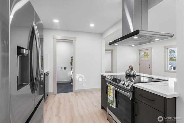 kitchen with recessed lighting, light countertops, appliances with stainless steel finishes, light wood-style floors, and island range hood