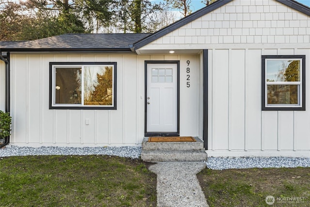 entrance to property with roof with shingles and board and batten siding