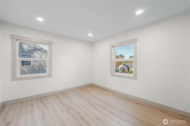 unfurnished room with recessed lighting, wood finished floors, and baseboards