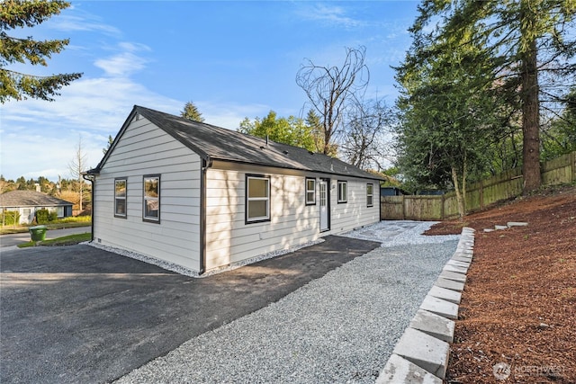 view of property exterior with a patio area and fence