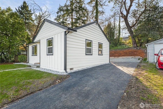 view of outbuilding featuring aphalt driveway