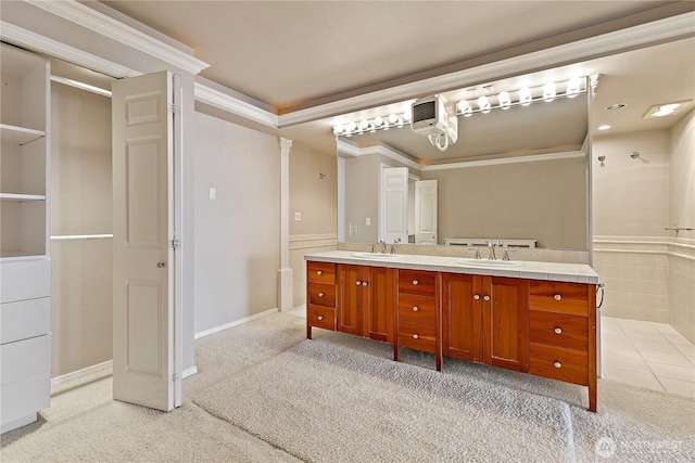 full bath with double vanity, crown molding, and a sink