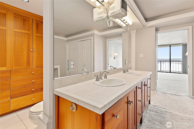 bathroom featuring double vanity, tile patterned flooring, crown molding, and a sink