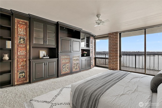 bedroom with light carpet, access to exterior, and floor to ceiling windows