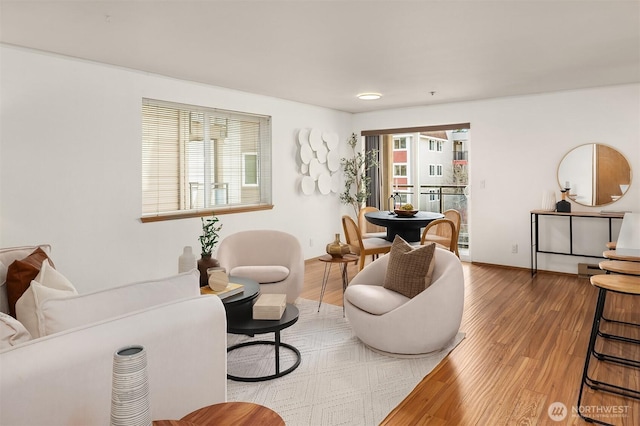 sitting room featuring plenty of natural light, baseboards, and wood finished floors