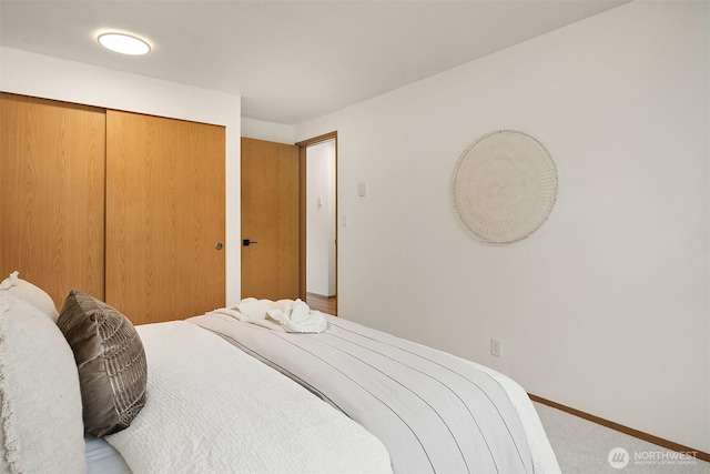 bedroom featuring baseboards, a closet, and carpet flooring