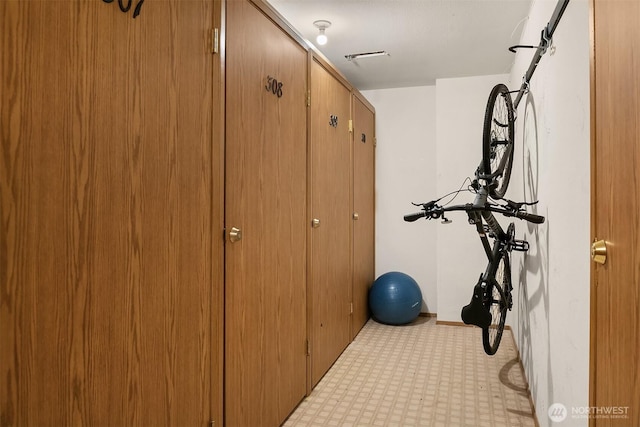 exercise area featuring light floors and baseboards