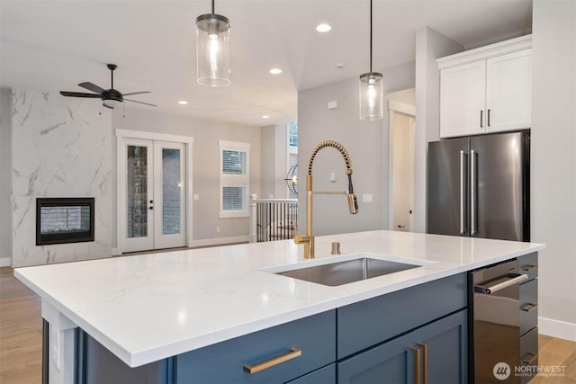 kitchen featuring recessed lighting, stainless steel appliances, a sink, open floor plan, and hanging light fixtures