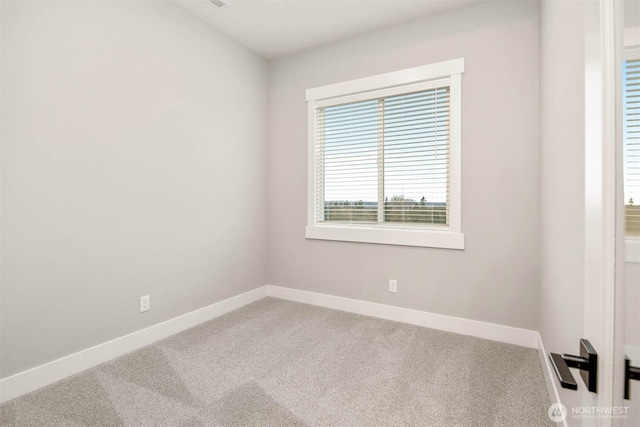 unfurnished room with baseboards and carpet flooring