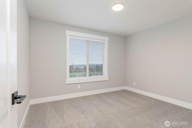 carpeted spare room featuring baseboards