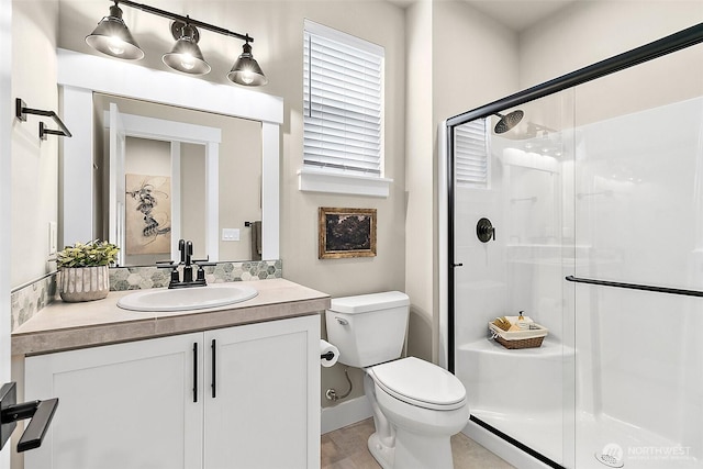 bathroom with toilet, a shower stall, and vanity