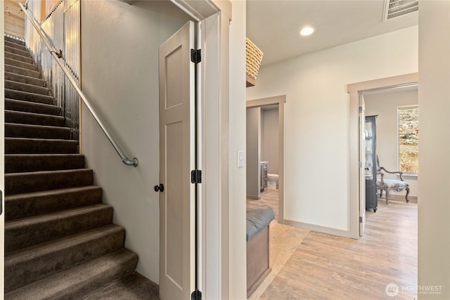 stairs featuring recessed lighting, visible vents, baseboards, and wood finished floors