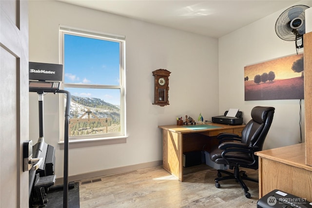 office space with visible vents, light wood-style flooring, and baseboards