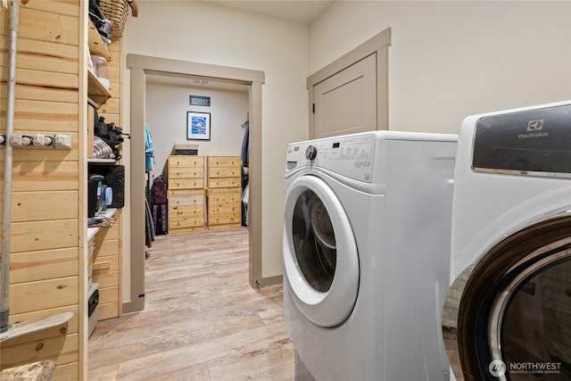 laundry room featuring light wood-style flooring and separate washer and dryer