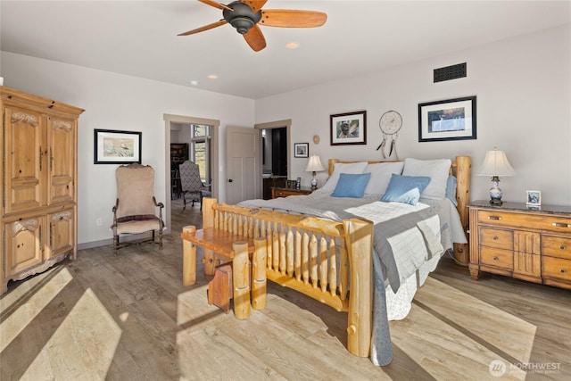 bedroom featuring light wood-type flooring, baseboards, visible vents, and a ceiling fan