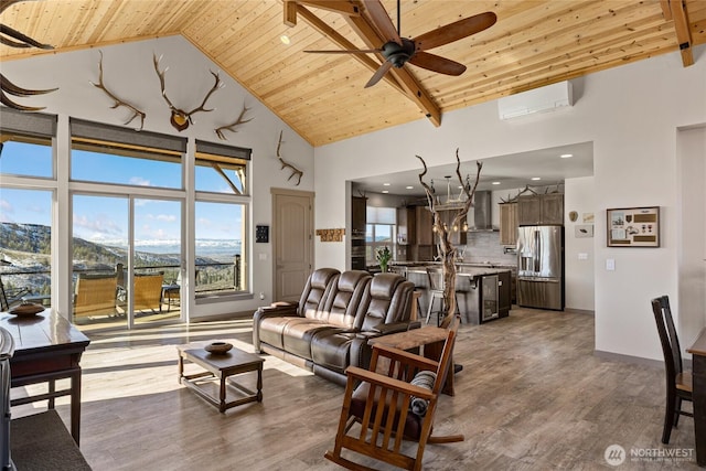 living area with baseboards, wood ceiling, wood finished floors, high vaulted ceiling, and a wall mounted AC