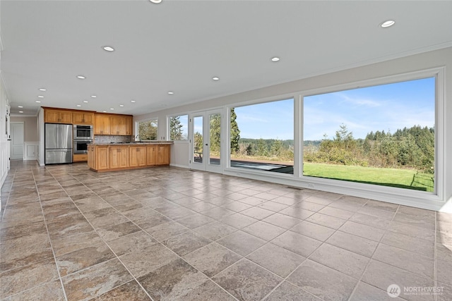 kitchen featuring a sink, recessed lighting, crown molding, and freestanding refrigerator