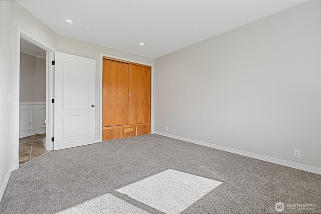 unfurnished bedroom featuring carpet floors, a decorative wall, and recessed lighting