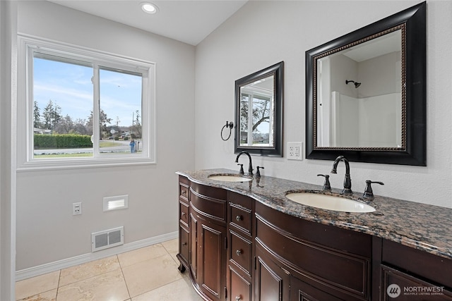 bathroom with double vanity, visible vents, a sink, and tile patterned floors