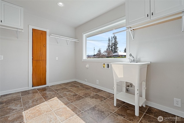 washroom with cabinet space, baseboards, washer hookup, and recessed lighting