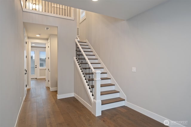 stairs with visible vents, baseboards, and wood finished floors